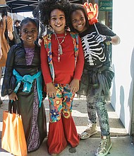 Casting a spell //
From left, spider sorceress Kayla Samuels and 1970s flower child Dior Flax, both 7, and skeleton Aniyah Thompson, 8, work magic with their smiles last Saturday as they shopped for candy and spotted zombies during the 12th Annual Zombie Walk in Carytown two days before Halloween. Please see more photos of costumed zombies, Page C2. 