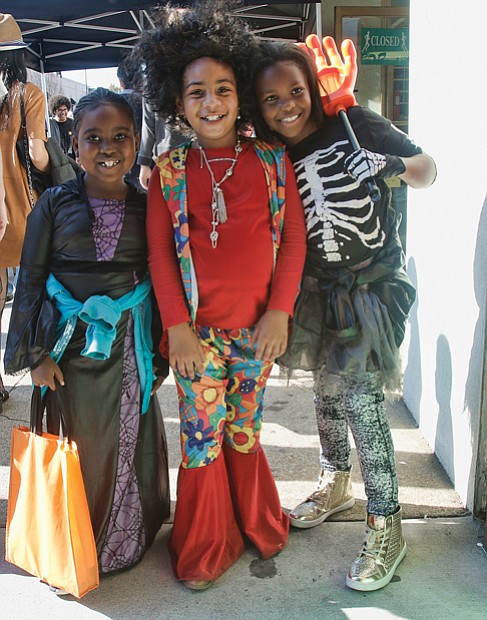 Casting a spell //
From left, spider sorceress Kayla Samuels and 1970s flower child Dior Flax, both 7, and skeleton Aniyah Thompson, 8, work magic with their smiles last Saturday as they shopped for candy and spotted zombies during the 12th Annual Zombie Walk in Carytown two days before Halloween. Please see more photos of costumed zombies, Page C2. 