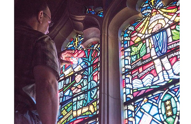 Andrew Goldkuhle of Goldkuhle Studios in Hanover County inspects and replaces stained glass images of the Confederate battle flag at Washington National Cathedral. The controversial flag was removed from two panes in August.