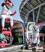 Warming hearts one coat at a time // Todd “Parney” Parnell, vice president and chief operating officer of the Richmond Flying Squirrels, works with team mascots Nutzy, left, and Nutasha to load coats in a van last Saturday during the 8th Annual Coats for Kids and Ballpark Warming Party at The Diamond. 
The Flying Squirrels were working with Coats for Kids sponsor, Puritan Cleaners, which collects about 15,000 coats for youngsters each November. The donated coats are washed, repaired and delivered to the Salvation Army for distribution to needy families in Central Virginia.
The collection event at The Diamond was part of the free Ballpark Warming Party, where fans of all ages enjoyed live music, chili tasting, crafts, games and raffle prizes, including baseball memorabilia.