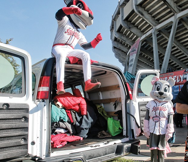 Warming hearts one coat at a time // Todd “Parney” Parnell, vice president and chief operating officer of the Richmond Flying Squirrels, works with team mascots Nutzy, left, and Nutasha to load coats in a van last Saturday during the 8th Annual Coats for Kids and Ballpark Warming Party at The Diamond. 
The Flying Squirrels were working with Coats for Kids sponsor, Puritan Cleaners, which collects about 15,000 coats for youngsters each November. The donated coats are washed, repaired and delivered to the Salvation Army for distribution to needy families in Central Virginia.
The collection event at The Diamond was part of the free Ballpark Warming Party, where fans of all ages enjoyed live music, chili tasting, crafts, games and raffle prizes, including baseball memorabilia.