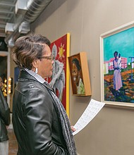 Celebrating artists //
The show features art from members of the Black American Art Association of Richmond, a new art collective. 
Scores of people attended the two-hour opening reception with the 13 artist-members of BAAAR. Bernie Johnson, left, admires a painting during the opening.
The exhibit features two pieces from each artist — one work from early in his or her career and a current piece, according to Mr. Browne.  
