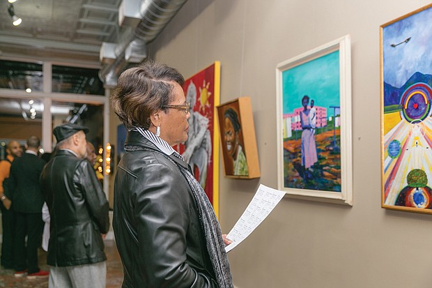 Celebrating artists //
The show features art from members of the Black American Art Association of Richmond, a new art collective. 
Scores of people attended the two-hour opening reception with the 13 artist-members of BAAAR. Bernie Johnson, left, admires a painting during the opening.
The exhibit features two pieces from each artist — one work from early in his or her career and a current piece, according to Mr. Browne.  
