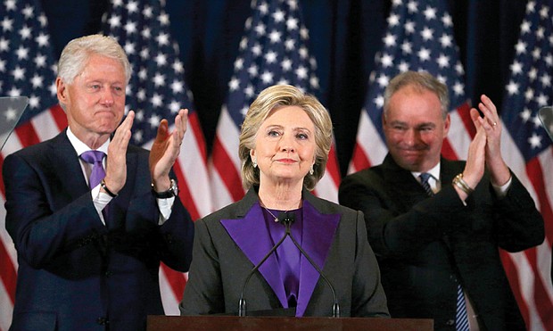 Democratic presidential candidate Hillary Clinton formally concedes to President-elect Donald Trump during a late-morning speech Wednesday to her staff and supporters at the Javits Convention Center in New York. Her husband, former President Bill Clinton, left, and her running mate, U.S. Sen. Tim Kaine of Virginia, applaud. 