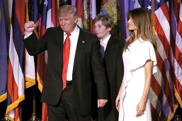 President-elect Donald Trump gestures to the crowd as he takes the stage to declare victory about 3 a.m. Wednesday at a rally in New York. His wife, Melania, and son, Baron, accompany him.