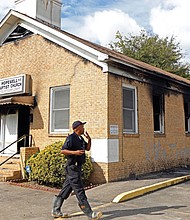 A fire marshal investigates damage at Hopewell Missionary Baptist Church in Greenville, Miss., which was burned and vandalized in a Nov. 1 fire.