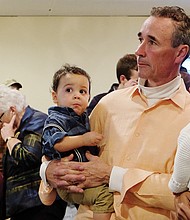 Mayoral candidate Joe Morrissey and his wife, Myrna, watch election results Tuesday night at his North Side campaign office. They hold their children, Chase, left, and Bella.