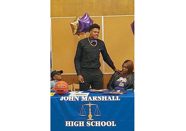 
John Marshall High School hoops standout Greg Jones makes his college choice official — James Madison University. His mother, Jennifer Mack, and brother, Diego Smith, were with him on signing day, Nov. 9, at the school library.