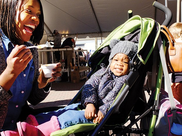 Soup’s on // Year-old Nevaeah Scott, above, has other interests rather than the stew offered by her mother, Deanna Scott, at the recent 2016 Brunswick Stew Festival.