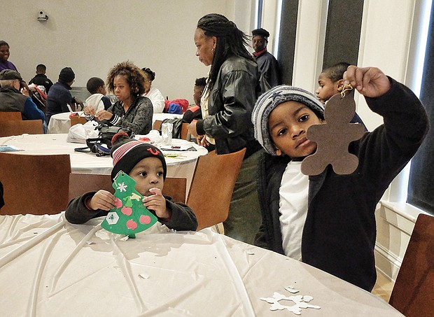 Quincey Grimes, 6, right, inspects the gingerbread man he decorated as his brother, Chase, 2, works on a Christmas tree. The two were making holiday ornaments for their father, Cedric Grimes. 
The museum, located at 122 W. Leigh St. in Jackson Ward, will host another holiday open house from noon to 4 p.m. Saturday, Dec. 10.