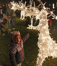 
Josiah Nicholas, 2, reaches out to touch a lighted reindeer during Friday’s Grand Illumination at the James Center. 