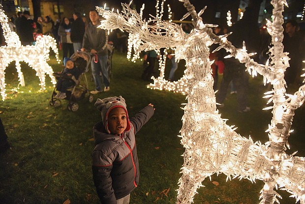 
Josiah Nicholas, 2, reaches out to touch a lighted reindeer during Friday’s Grand Illumination at the James Center. 