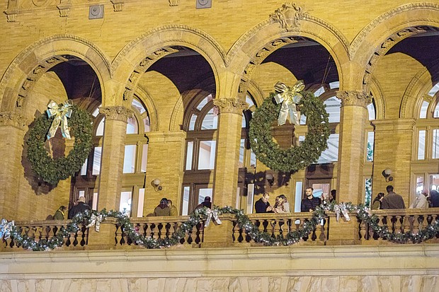 Spectators break into applause as the 46-foot Christmas tree at the James Center lights up with the city skyline and the Richmond Boys Choir serenades the crowd. Below, giant wreaths and yards of garlands adorn Main Street Station in Shockoe Bottom, where people enjoyed music, food trucks and a free movie last Friday night.
