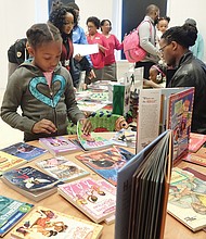 Open house at museum // Dozens of families enjoyed refreshments, arts and crafts, activities and exhibits at the annual Holiday Open House at the Black History Museum and Cultural Center of Virginia, featuring Soul Santa.
Above, Ma’Tazia Wormley, 7, inspects the selection of free books donated by Sistahs Book Club, while Ronnie Nelson Sidney, right, author of the highly acclaimed children’s book “Nelson Beats the Odds,” signs copies of his book. 
