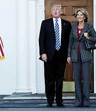 President-elect Donald Trump stands with Betsy DeVos, his nominee for U.S. secretary of education, after their meeting Nov. 19 at the main clubhouse at Trump National Golf Club in Bedminster, N.J.