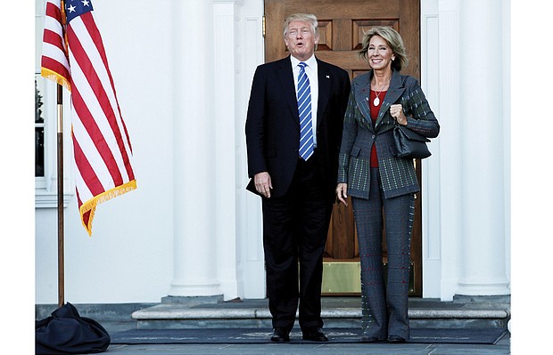 President-elect Donald Trump stands with Betsy DeVos, his nominee for U.S. secretary of education, after their meeting Nov. 19 at the main clubhouse at Trump National Golf Club in Bedminster, N.J.