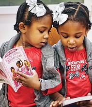 Double the holiday fun //
Twins Layla, left, and Leyah DeBruhl, 4, compare books they received Saturday at the annual Holiday Open House at the Black History Museum and Cultural Center of Virginia. More than 160 books were donated by the Sistahs Book Club for the free event. More photos, B2.