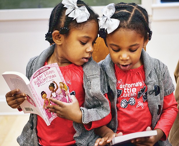 Double the holiday fun //
Twins Layla, left, and Leyah DeBruhl, 4, compare books they received Saturday at the annual Holiday Open House at the Black History Museum and Cultural Center of Virginia. More than 160 books were donated by the Sistahs Book Club for the free event. More photos, B2.