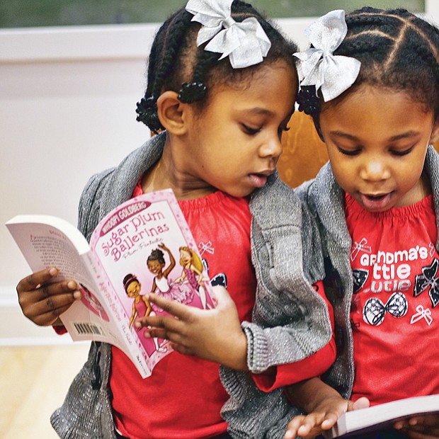 Double the holiday fun //
Twins Layla, left, and Leyah DeBruhl, 4, compare books they received Saturday at the annual Holiday Open House at the Black History Museum and Cultural Center of Virginia. More than 160 books were donated by the Sistahs Book Club for the free event. More photos, B2.