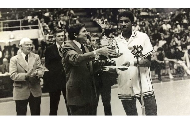 At the Aron Stewart Day ceremony in February 1974, the University of Richmond basketball star is presented with a trophy by UR President E. Bruce Heilman, while former Coach Mac Pitt, far left, applauds.