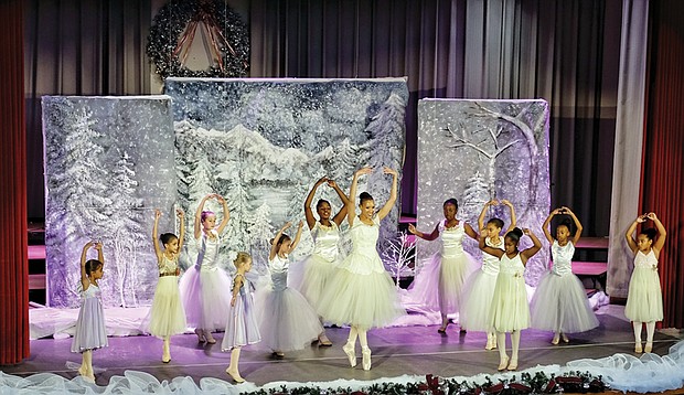 the Dance Candle Academy of Performing and Sacred Arts founder Karen Watkins Rios, center, performs a perfect relevé with her dancers during “Clara’s Christmas Gift” on Saturday. 