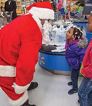 
Kevasia Taylor, 5, center, takes a break from shopping to rattle off her detailed Christmas list to Santa Claus, while 10-year-old Quanasia Hubbard waits to share her list during the Prince Hall Masons’ Operation Santa Claus last Saturday. Location: Walmart on Sheila Lane in South Side. 