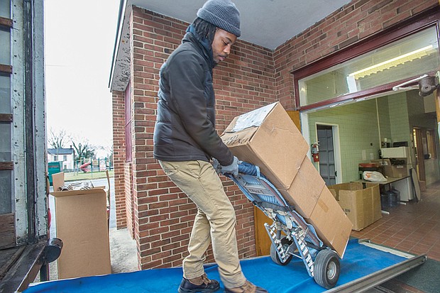Isaac Lee, left, loads a truck with boxes Saturday from Norrell School Annex at 201 W. Graham Road in North Side. The annex and the nearby A.V. Norrell Elementary School building, which have been used as office space in recent years, are being closed to help Richmond Public Schools save money. The move is to be completed by February, and the buildings are to be returned to ownership by the City of Richmond.