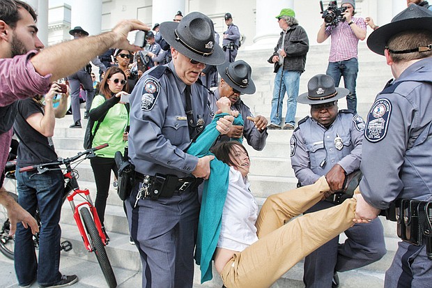 Capitol Police carry away a demonstrator who refused to leave the south steps of the Capitol during a February protest of utility giant Dominion’s plans to deal with coal ash. About eight people were arrested.