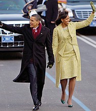 Mrs. Obama wears a two-piece lemongrass-hued ensemble by Cuban-American designer Isabel Toledo as she walks down Pennsylvania Avenue with newly sworn-in President Obama in January 2009. 