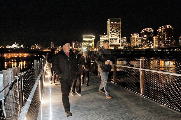 The first pedestrians stream across the newly opened T. Tyler Potterfield Memorial Bridge over the James River following the ribbon-cutting in December during the Grand Illumination in Downtown.
