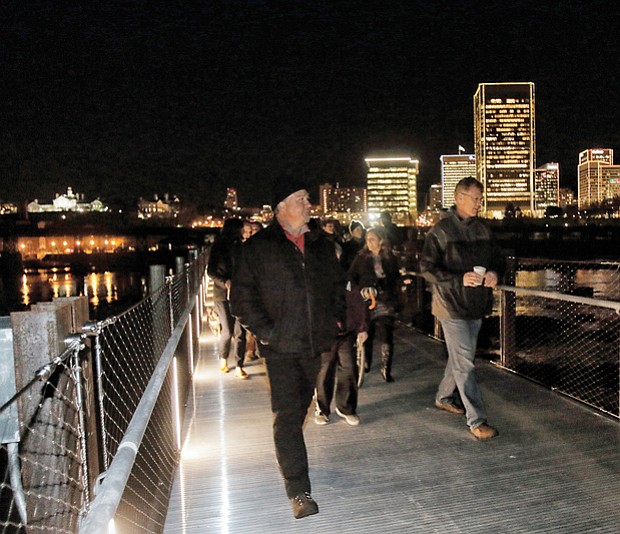 The first pedestrians stream across the newly opened T. Tyler Potterfield Memorial Bridge over the James River following the ribbon-cutting in December during the Grand Illumination in Downtown.

