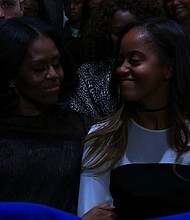President Obama makes his final presidential speech to the nation on January 10, 2017 in Chicago, Illinois. First Lady Michelle Obama and their daughter smile listening to her husband's speech.