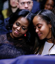 First Lady Michelle Obama and daughter Malia embrace as President Obama warmly acknowledges them during his speech.