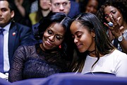 First Lady Michelle Obama and daughter Malia embrace as President Obama warmly acknowledges them during his speech.