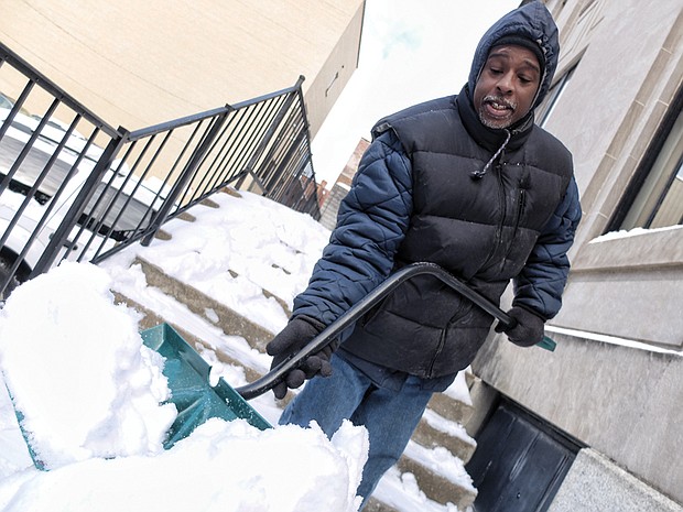 Kelvin White clears away snow at 5th and Franklin streets in Downtown, just one of the legions who shoveled steps, sidewalks and parking places across the area. 