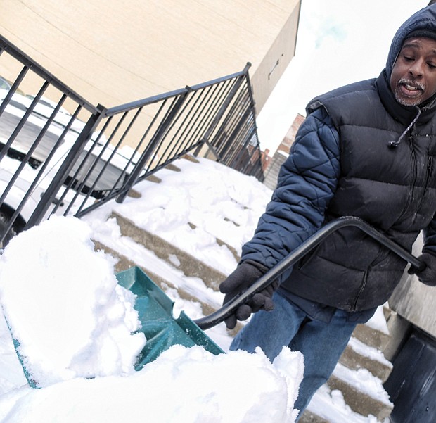 Kelvin White clears away snow at 5th and Franklin streets in Downtown, just one of the legions who shoveled steps, sidewalks and parking places across the area. 