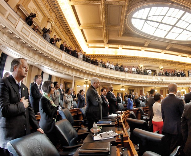 Lawmakers return to Richmond // Left, members of the Virginia House of Delegates recite the Pledge of Allegiance at the state Capitol on Wednesday on the opening day of the new General Assembly session. The 100-member House and 40-member Senate will amend the state budget and deal with more than 2,000 bills during the 46-day session. 
 