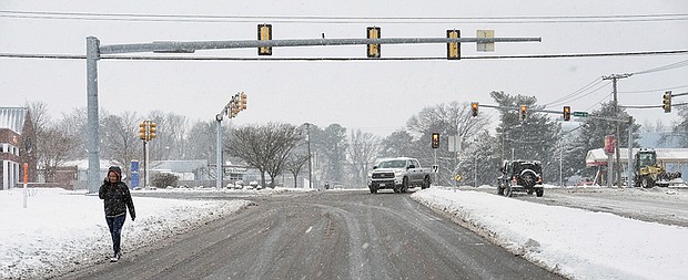 Intrepid pedestrians and motorists are quickly out and about after the snow stops falling Saturday. Location: Parham Road and Broad Street in Western Henrico.