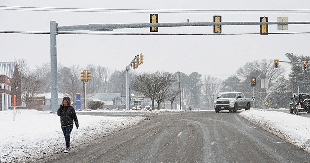 Intrepid pedestrians and motorists are quickly out and about after the snow stops falling Saturday. Location: Parham Road and Broad Street in Western Henrico.