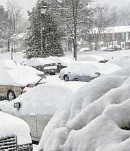 Parked cars at Muldoon Court and Shrader Road are blanketed with snow Saturday. 