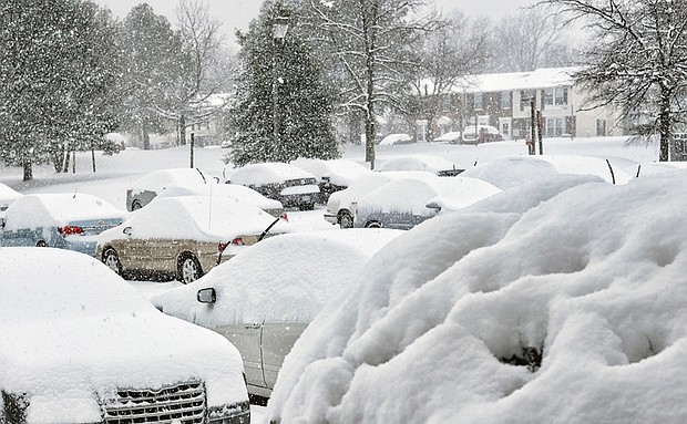 Parked cars at Muldoon Court and Shrader Road are blanketed with snow Saturday. 