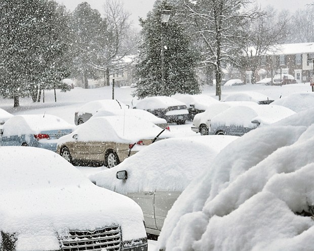 Parked cars at Muldoon Court and Shrader Road are blanketed with snow Saturday. 