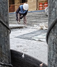 A worker from Stonee Masonry of Henrico County crafts new steps for the Main Library in Downtown. The facelift was needed because the old steps were cracked and broken. The nearly $100,000 project is almost complete, despite delays from recent snow and rain.  