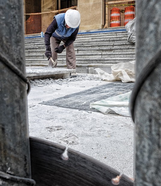 A worker from Stonee Masonry of Henrico County crafts new steps for the Main Library in Downtown. The facelift was needed because the old steps were cracked and broken. The nearly $100,000 project is almost complete, despite delays from recent snow and rain.  