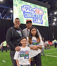 Michael Muñoz and father Anthony Muñoz strike a pose with NFL Play 60 Character Camp participants Christian Diaz, 11 and Nallely Pozos, 13