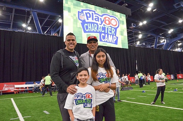 Michael Muñoz and father Anthony Muñoz strike a pose with NFL Play 60 Character Camp participants Christian Diaz, 11 and Nallely Pozos, 13
