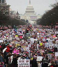 Protesters walk during the Women's March on Washington, with the U.S. Capitol in the background, on January 21, 2017 in Washington, DC. (Photo by Mario Tama/Getty Images)
