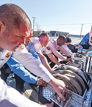 Cityscape // Clement Britt
 
Richmond Fire Capt. Robert Maass leads members of Engine Co. No. 13 and Mayor Levar Stoney, second from right, in ceremoniously pushing their new truck into the station Saturday, although the vehicle actually was being driven slowly in reverse. Location: 411 Commerce Road. The new truck was put into service during the “housing ceremony.” It is one of nine the city Fire Department has ordered since 2012 under a replacement program initiated under former Mayor Dwight C. Jones. This is the first new truck to arrive since April 2016. The city’s goal is to replace over time the trucks that the city’s 19 engine companies deploy to reduce the cost of keeping outdated equipment in service.  