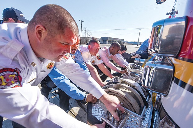 Cityscape // Clement Britt
 
Richmond Fire Capt. Robert Maass leads members of Engine Co. No. 13 and Mayor Levar Stoney, second from right, in ceremoniously pushing their new truck into the station Saturday, although the vehicle actually was being driven slowly in reverse. Location: 411 Commerce Road. The new truck was put into service during the “housing ceremony.” It is one of nine the city Fire Department has ordered since 2012 under a replacement program initiated under former Mayor Dwight C. Jones. This is the first new truck to arrive since April 2016. The city’s goal is to replace over time the trucks that the city’s 19 engine companies deploy to reduce the cost of keeping outdated equipment in service.  