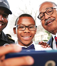 Nick Booker, a seventh-grader at Richmond Preparatory Christian Academy’s Douglass School, takes a selfie with aviator Barrington Irving, left, following Mr. Irving’s talk Wednesday to several hundred students at the Science Museum of Virginia. Also in the selfie is Elbert Brinson, dean of the Douglass School.